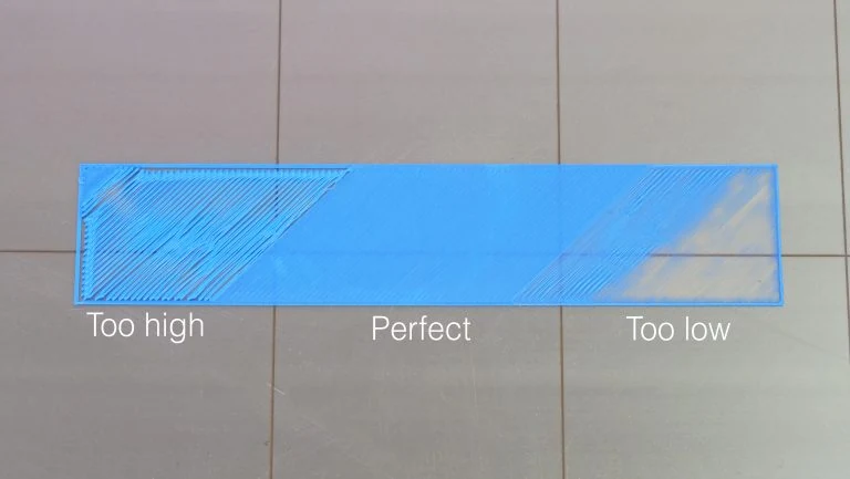 Prusa comparison of a blue first layer printed with too much, correct and too little nozzle clearance.